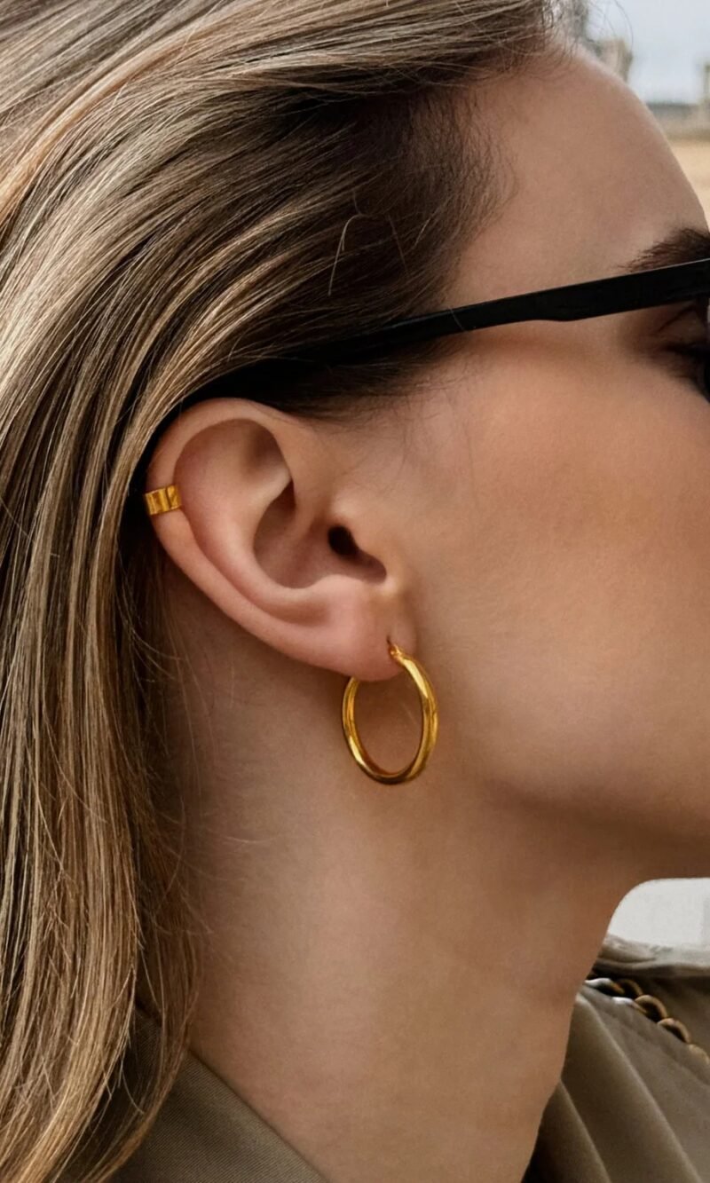 Gold hoop earrings with a minimalist design, featuring a smooth polished finish and a timeless circular shape, elegant and versatile for everyday wear.