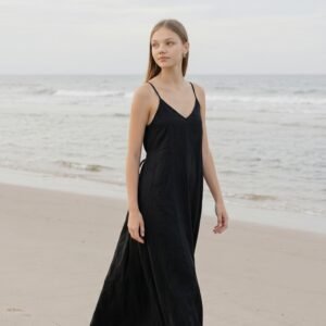 Model wearing black linen cami dress Lila on the beach