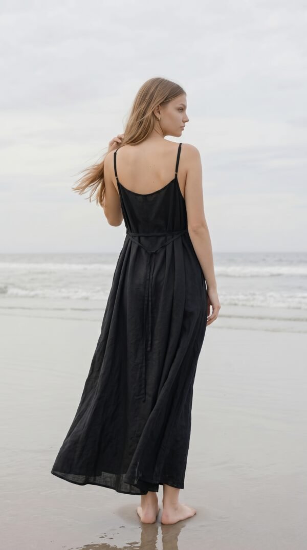 Model wearing black linen cami dress Lila on the beach