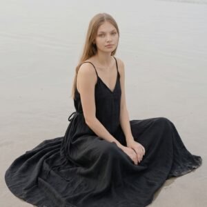 Model wearing black linen cami dress Lila on the beach